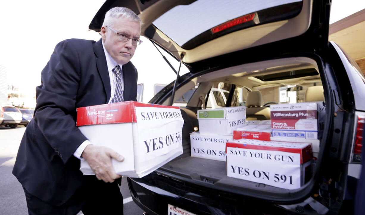 Ray Carter, executive director of Washington Arms Collectors, helps deliver the first batch of signatures for a gun rights initiative to the secretary of state's office Thursday in Olympia.