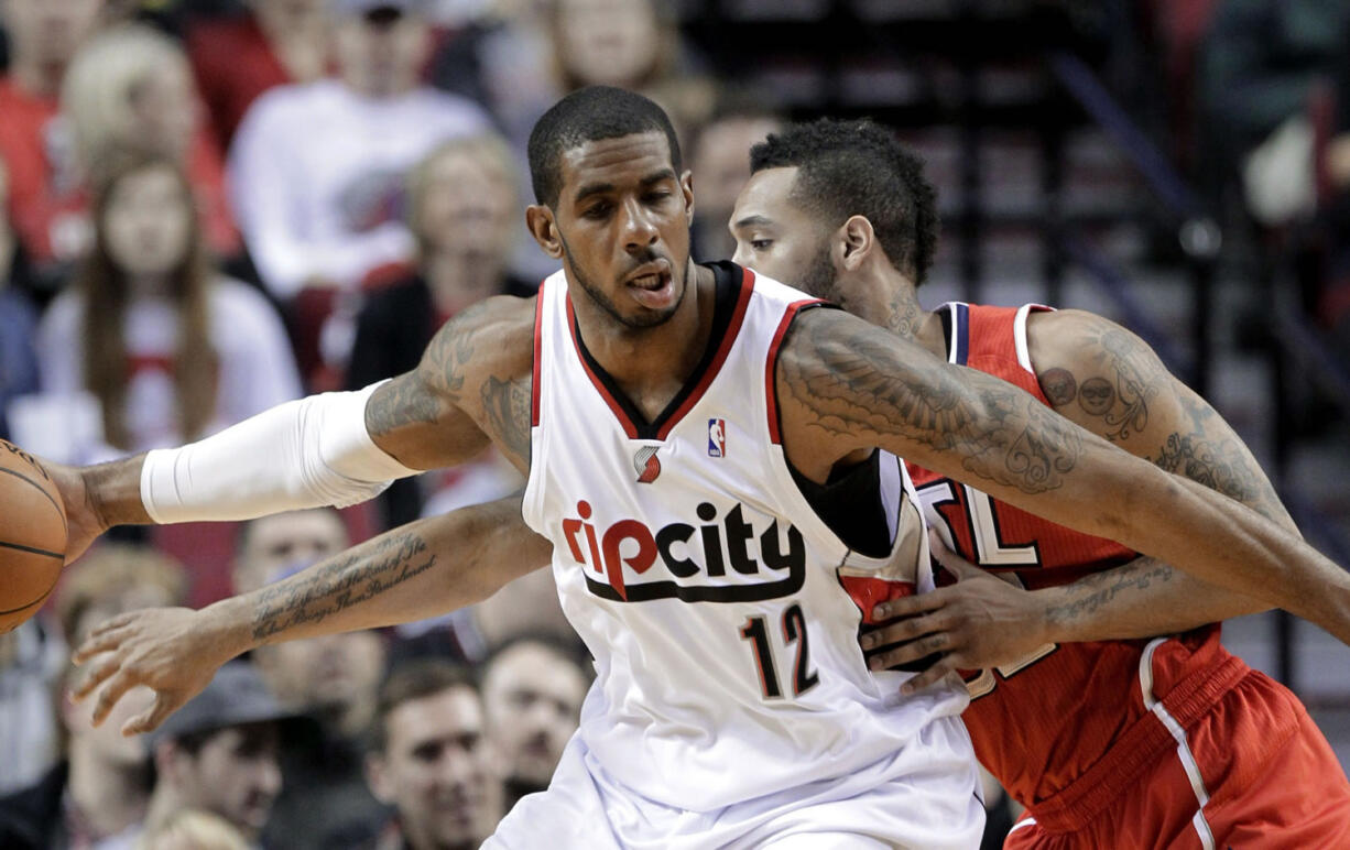 Atlanta Hawks forward Mike Scott, right, plays tight defense on Portland Trail Blazers forward LaMarcus Aldridge during the first half of an NBA basketball game in Portland, Ore., Wednesday, March 5, 2014.