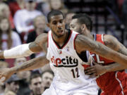 Atlanta Hawks forward Mike Scott, right, plays tight defense on Portland Trail Blazers forward LaMarcus Aldridge during the first half of an NBA basketball game in Portland, Ore., Wednesday, March 5, 2014.