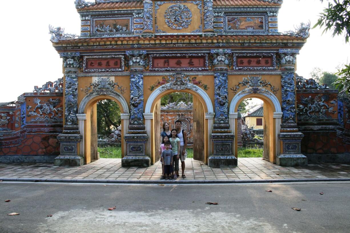 Michelle Robin La, rear left, stands with her husband, Luong La, and their three children at the Citadel in Hue, Vietnam. The family was taking part in a heritage trip to Vietnam, where Luong La grew up. The National Trust for Historic Preservation defines heritage tourism as traveling to experience a place, artifacts and activities that authentically represent the stories and people of the past and present.