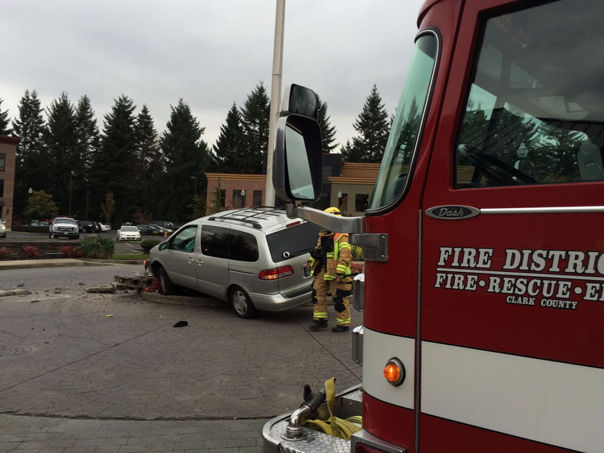 A Fire District 6 firefighter inspects a Toyota Sienna minivan that struck a light pole Thursday afternoon.