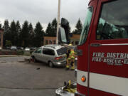 A Fire District 6 firefighter inspects a Toyota Sienna minivan that struck a light pole Thursday afternoon.