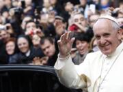 Pope Francis waves as he leaves Rome's Jesus' Church to celebrate a mass with the Jesuits, on the occasion of the order's titular feast Friday.