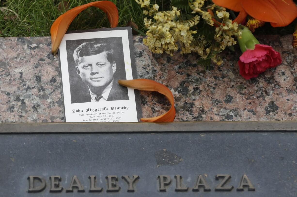 A photo of President Kennedy and flowers rest on a plaque at Dealey Plaza in Dallas on Thursday.