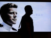 Museum visitor Edmilson Da Cruz, of Hayward, Calif., center, is silhouetted in front of a World War II era photograph of John F. Kennedy in an exhibit  titled &quot;Young Jack&quot; at the John F. Kennedy Presidential Library and Museum, Thursday, Nov. 5, 2015, in Boston. The new exhibit is devoted to the 35th U.S. president&#039;s early years.