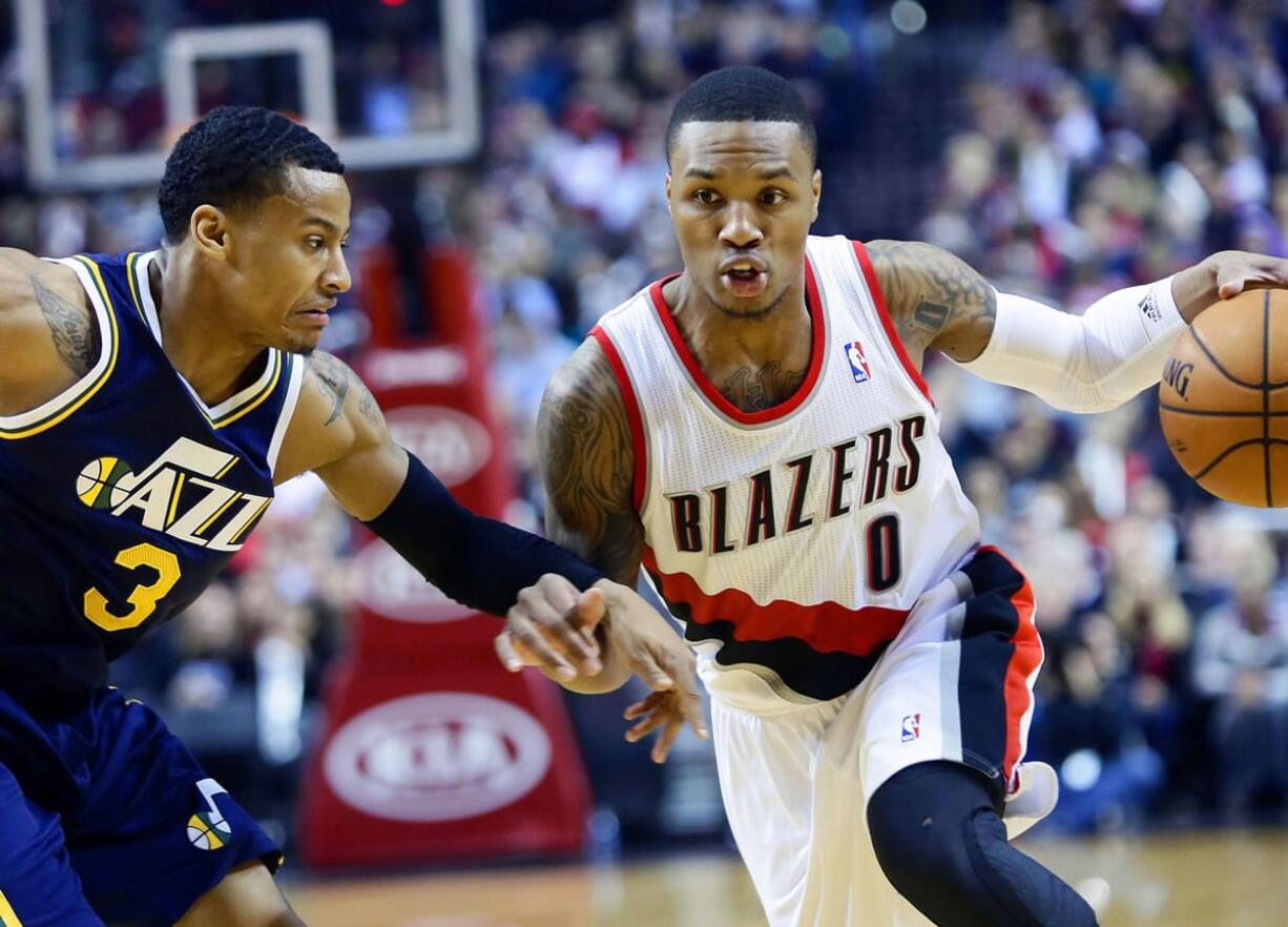 Portland Trail Blazers guard Damian Lillard, right, drives on Utah Jazz guard Trey Burke during the first half  Friday.