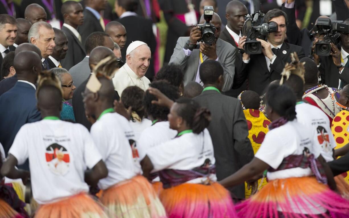 Pope Francis greets traditional dancers on his arrival at the airport in Nairobi, Kenya, on Wednesday. Pope Francis left Wednesday for his first-ever visit to the continent, a whirlwind pilgrimage to Kenya, Uganda and the Central African Republic, bringing a message of peace and reconciliation to an Africa torn by extremist violence.