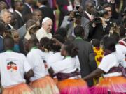 Pope Francis greets traditional dancers on his arrival at the airport in Nairobi, Kenya, on Wednesday. Pope Francis left Wednesday for his first-ever visit to the continent, a whirlwind pilgrimage to Kenya, Uganda and the Central African Republic, bringing a message of peace and reconciliation to an Africa torn by extremist violence.