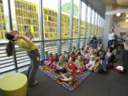 Elsbeth Casimir with the children's services department at the Vancouver Community Library reads the book &quot;Shark in the Park&quot; during a story time program.