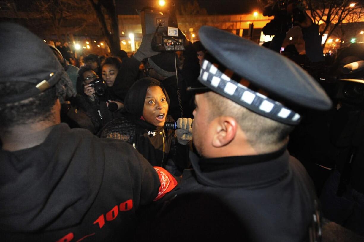 A protester yells at police officers outside the District 1 central headquarters late Tuesday in Chicago during a protest over the fatal shooting of 17-year-old Laquan McDonald by police in October 2014.