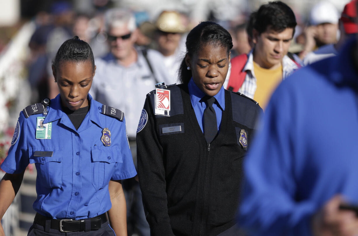 Two Transportation Security Administration agents walk with others after Terminal 2 was reopened at Los Angeles International Airport on Nov.