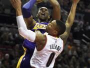 Los Angeles Lakers forward Kobe Bryant (24) shoots the ball over Portland Trail Blazers guard Damian Lillard (0) during the first half of an NBA basketball game on Saturday, Nov. 28, 2015, in Portland, Ore.