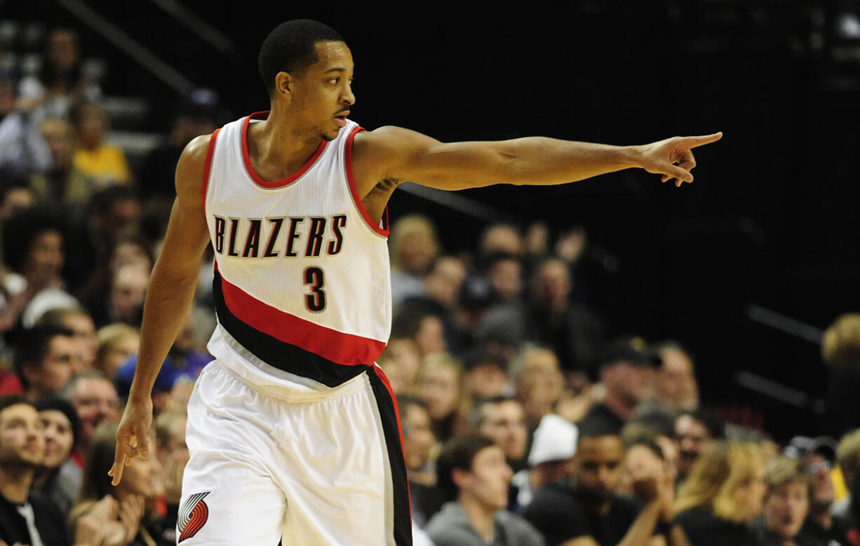 Portland Trail Blazers guard C.J. McCollum (3) points to the bench after hitting a three-point shot during the first half of an NBA basketball game against the Los Angeles Lakers on Saturday, Nov. 28, 2015, in Portland, Ore.