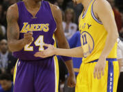 Los Angeles Lakers guard Kobe Bryant (24) greets Golden State Warriors guard Klay Thompson (11) before an NBA basketball game in Oakland, Calif., Tuesday, Nov. 24, 2015.