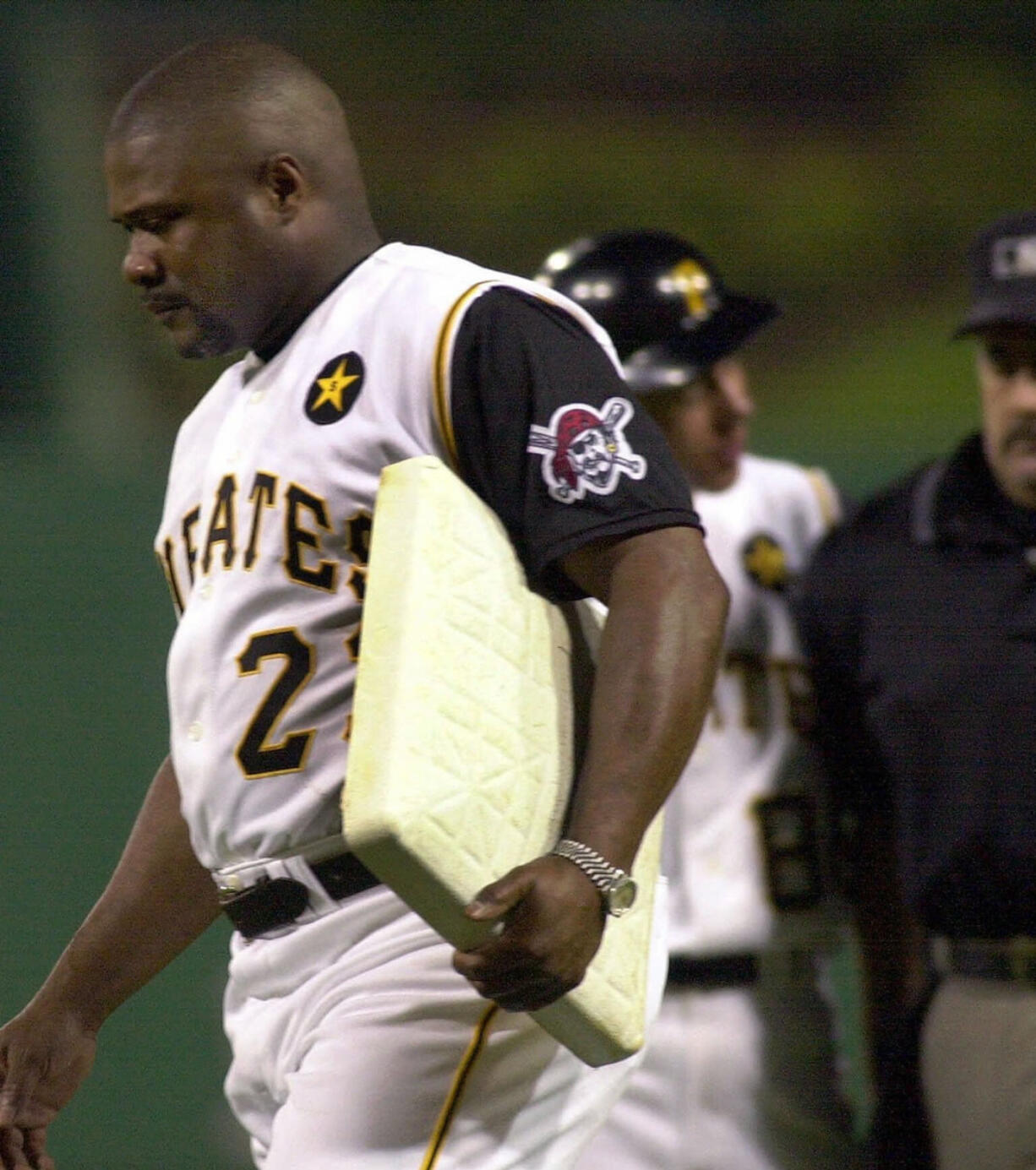 Pittsburgh Pirates manager Lloyd McClendon walks off the field carrying first base after being tossed from the game against the Milwaukee Brewers for arguing a call at first with umpire Rick Reed in this June 26, 2001 photo, in Pittsburgh. (AP Photo/Gene J.