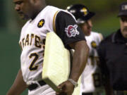 Pittsburgh Pirates manager Lloyd McClendon walks off the field carrying first base after being tossed from the game against the Milwaukee Brewers for arguing a call at first with umpire Rick Reed in this June 26, 2001 photo, in Pittsburgh. (AP Photo/Gene J.