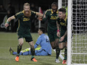 Portland Timbers defender Nat Borchers (7) forward Fanendo Adi and defender Liam Ridgewell, right, celebrate Ridgewell's goal during the first half of the first leg of the MLS soccer Western Conference championship against FC Dallas in Portland, Ore., Sunday, Nov. 22, 2015.