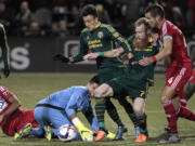 Portland Timbers defender Nat Borchers (7) shoots and scores next to Portland Timbers midfielder Maximiliano Urruti (37), against FC Dallas goalkeeper Jesse Gonzalez (44) and defender Matt Hedges (24) during the second half of the first leg of the MLS soccer Western Conference championship in Portland, Ore., Sunday, Nov. 22, 2015.