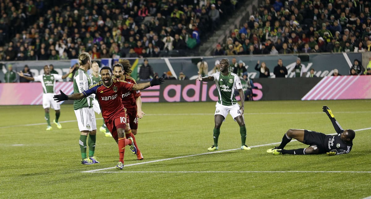 Real Salt Lake's Robbie Findley (10) celebrates after he scored a goal on Portland Timbers goalkeeper Donovan Ricketts, right, in the first half of the second game of the Western Conference finals in the MLS Cup soccer playoffs Sunday, Nov. 24, 2013, in Portland, Ore. (AP Photo/Ted S.