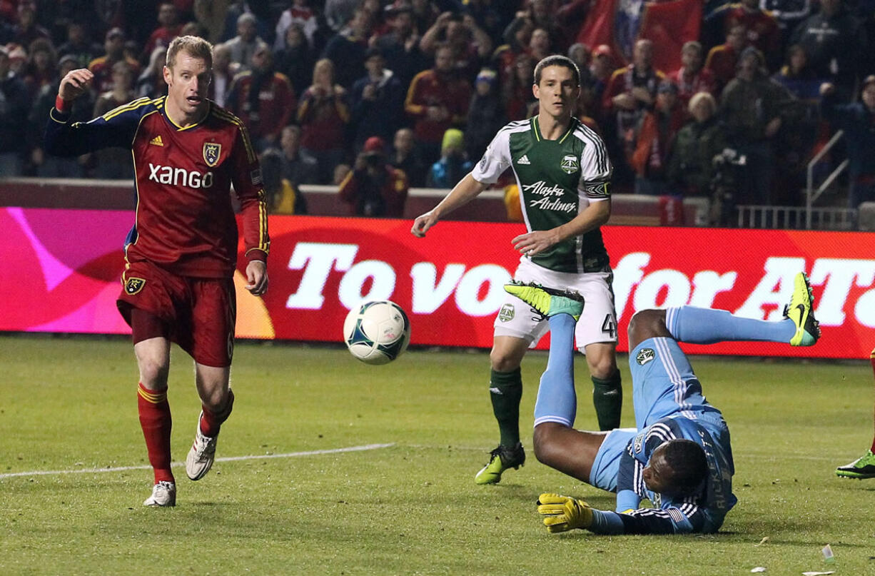 Portland Timbers goalie Donovan Ricketts, right, dives for a save as Real Salt Lake defender Nat Borchers, left, stands by in the first half during the first leg of the MLS Western Conference final Sunday, Nov. 10, 2013, in Sandy, Utah.