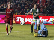 Portland Timbers goalie Donovan Ricketts, right, dives for a save as Real Salt Lake defender Nat Borchers, left, stands by in the first half during the first leg of the MLS Western Conference final Sunday, Nov. 10, 2013, in Sandy, Utah.