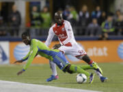 Seattle Sounders' Eddie Johnson, left, goes down as he battles with Portland Timbers' Mamadou Danso (98) for the ball in the first half of the first game of the Western Conference semifinals in the MLS Cup soccer playoffs, Saturday, Nov. 2, 2013, in Seattle. (AP Photo/Ted S.