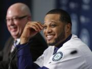 Robinson Cano, right, smiles as he sits next to Seattle Mariners general manager Jack Zduriencik, left, after Cano was introduced as the newest member of the Seattle Mariners on Thursday.