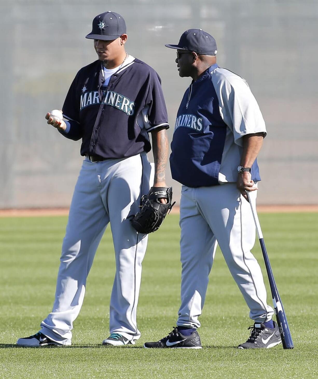 Seattle Mariners pitcher Felix Hernandez talks with manager Lloyd McClendon during their first spring training baseball practice Thursday at Peoria, Ariz.