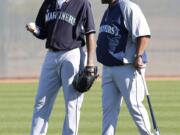 Seattle Mariners pitcher Felix Hernandez talks with manager Lloyd McClendon during their first spring training baseball practice Thursday at Peoria, Ariz.