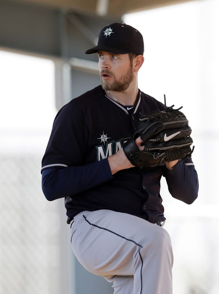 Seattle Mariners' James Paxton winds up to deliver a pitch in a bullpen session during baseball spring training in Peoria, Ariz.