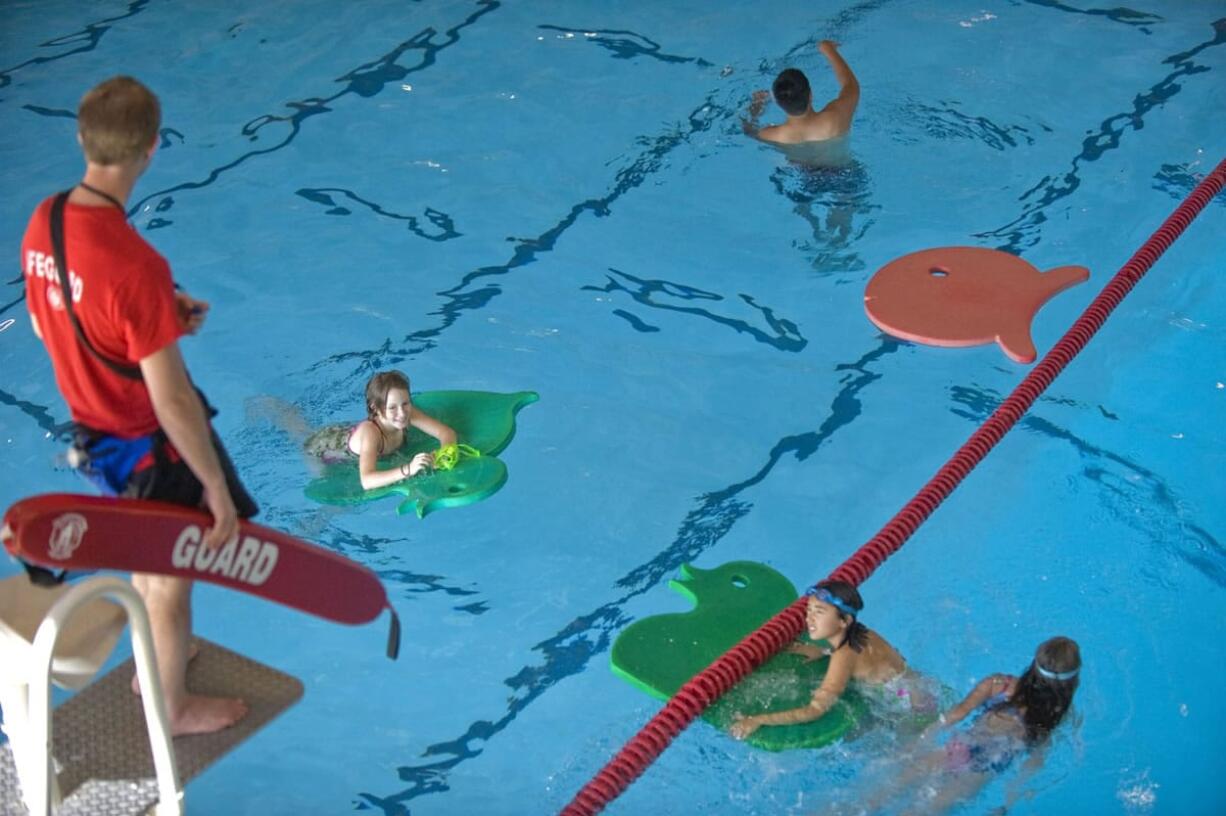 Children swim in to the pool at the Marshall Center.