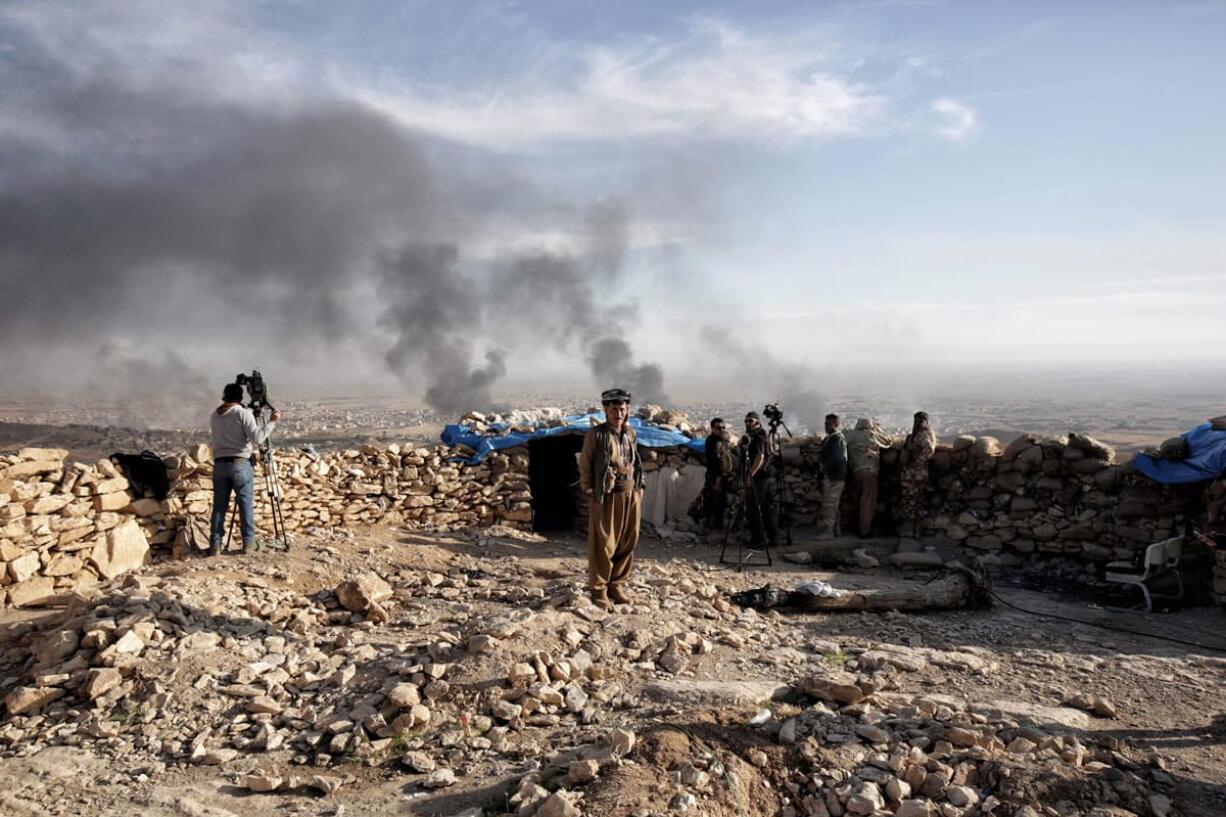 Smoke rises over Sinjar, northern Iraq from oil fires set by Islamic State militants as Kurdish Iraqi fighters, backed by U.S.-led airstrikes, launch a major assault on Thursday. The strategic town of Sinjar was overran last year  by the Islamic State group in an onslaught that caused the flight of tens of thousands of Yazidis and first prompted the United States to launch the air campaign against the militants.