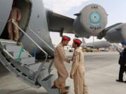 United Arab Emirates pilots greet each other at the steps of a Boeing C-17 Globemaster III, a large military transport aircraft of the UAE Air forces during the opening day of the Dubai Airshow in Dubai, United Arab Emirates, on Sunday.