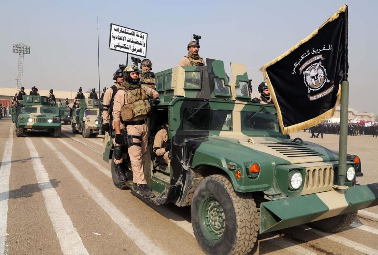 Iraqi Tactical team of Intelligence and the FBI march during a ceremony marking Police Day at the police academy in Baghdad, Iraq, on Thursday.