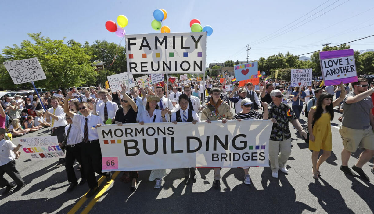 Members of the Mormons Building Bridges march June 2, 2013, during the Utah Gay Pride Parade in Salt Lake City. Gay and lesbian Mormons and their supporters are reeling over a rule change by church officials that says members in same-sex marriages can be kicked out, and bars their children from being baptized unless they disavow same-sex relationships. The changes in the church handbook were sent out Thursday to local church leaders around the world. The Church of Jesus Christ of Latter-day Saints spokesman Eric Hawkins said in a statement Friday the revisions reiterate church opposition to gay marriage.