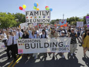 Members of the Mormons Building Bridges march June 2, 2013, during the Utah Gay Pride Parade in Salt Lake City. Gay and lesbian Mormons and their supporters are reeling over a rule change by church officials that says members in same-sex marriages can be kicked out, and bars their children from being baptized unless they disavow same-sex relationships. The changes in the church handbook were sent out Thursday to local church leaders around the world. The Church of Jesus Christ of Latter-day Saints spokesman Eric Hawkins said in a statement Friday the revisions reiterate church opposition to gay marriage.