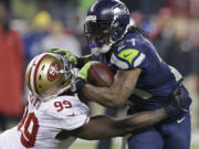 Seattle Seahawks' Marshawn Lynch tries to run past San Francisco 49ers' Aldon Smith during the second half of the NFL football NFC Championship game Sunday, Jan. 19, 2014, in Seattle.