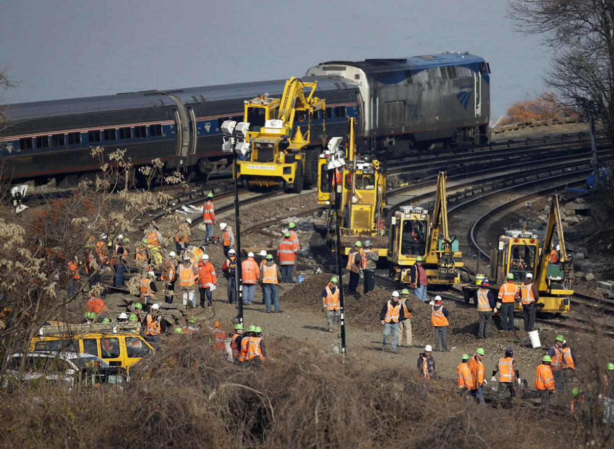 A train passes by the scene of repair efforts at the site of a train derailment in the Bronx borough of New York on Tuesday.