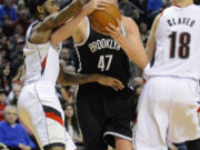 Brooklyn Nets' Andrei Kirilenko (47) drives against Portland Trail Blazers' Will Barton (5) and Victor Claver (18) during the first half Wednesday.