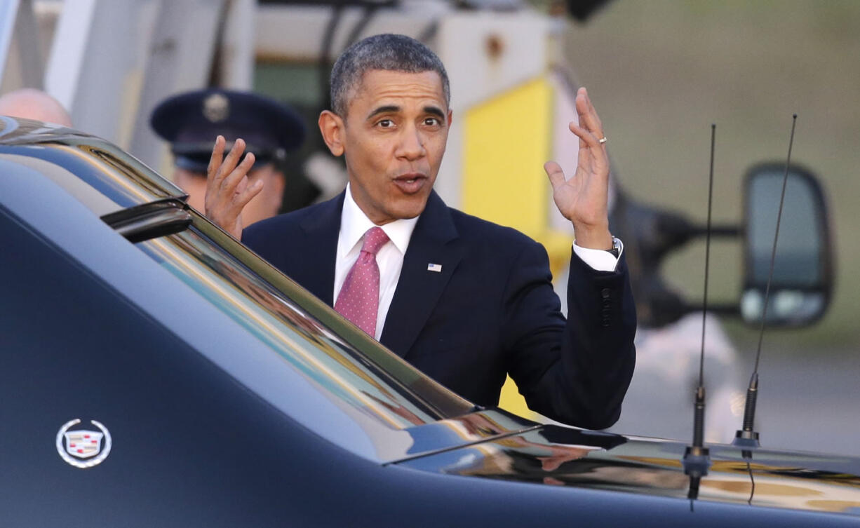 President Barack Obama motions toward media members after arriving Sunday at Seattle-Tacoma International Airport.