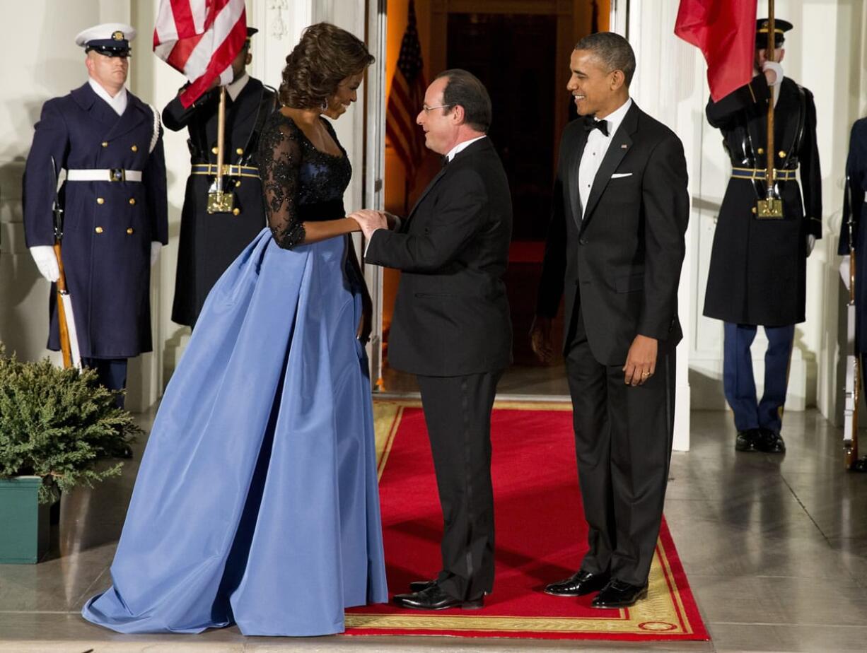 First lady Michelle Obama and President Barack Obama welcome French President Francois Hollande, center, to a state dinner at the White House on Tuesday.