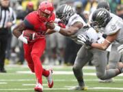 Arizona running back Ka'Deem Carey (25) tries to slip around Oregon linebacker Boseko Lokombo (25) during the first quarter Saturday. Carey finished with 206 yards rushing on 48 carries and four touchdowns.