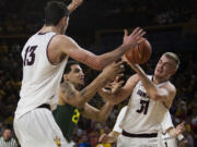 Oregon center Waverly Austin, center, and Arizona State forward Jonathan Gilling, right, try to control of the ball during Saturday's Pac-12 Conference game at Tempe, Ariz.