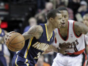 Indiana Pacers guard George Hill, left, drives on Portland Trail Blazers guard Damian Lillard during the first half of Monday's game at the Moda Center.