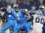 Carolina Panthers quarterback Cam Newton (1) throws a pass under pressure from Dallas Cowboys defensive end Demarcus Lawrence (90) in the first half of an NFL football game, Thursday, Nov. 26, 2015, in Arlington, Texas.