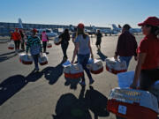 Volunteers carry rescue dogs across the tarmac to board planes at the Van Nuys Airport in Los Angeles on Friday. More than 800 cats and dogs from California animal shelters took off for Washington, Oregon, Idaho, Montana, Illinois and Wisconsin in the largest Holiday Pet Airlift the Wings of Rescue has undertaken. It took 22 private planes and more than 200 volunteers to get the animals off the ground.