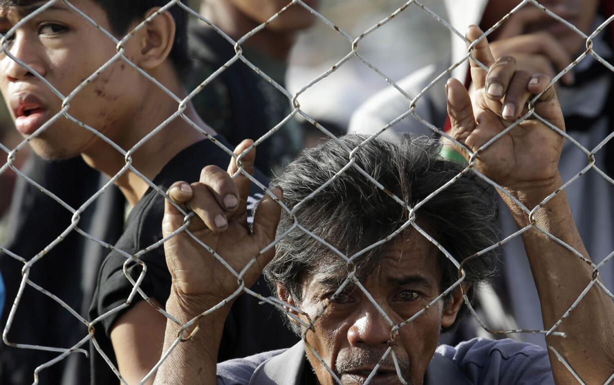 Residents queue up to receive treatment and relief supplies at Tacloban airport following Friday's typhoon Haiyan that lashed this city and several provinces in central Philippines.