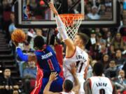 Detroit Pistons guard Reggie Jackson (1) drives to the basket and scores on Portland Trail Blazers forward Meyers Leonard (11) during the fourth quarter of an NBA basketball game in Portland, Ore., Sunday, Nov. 8, 2015. The Pistons won the game 120-103.