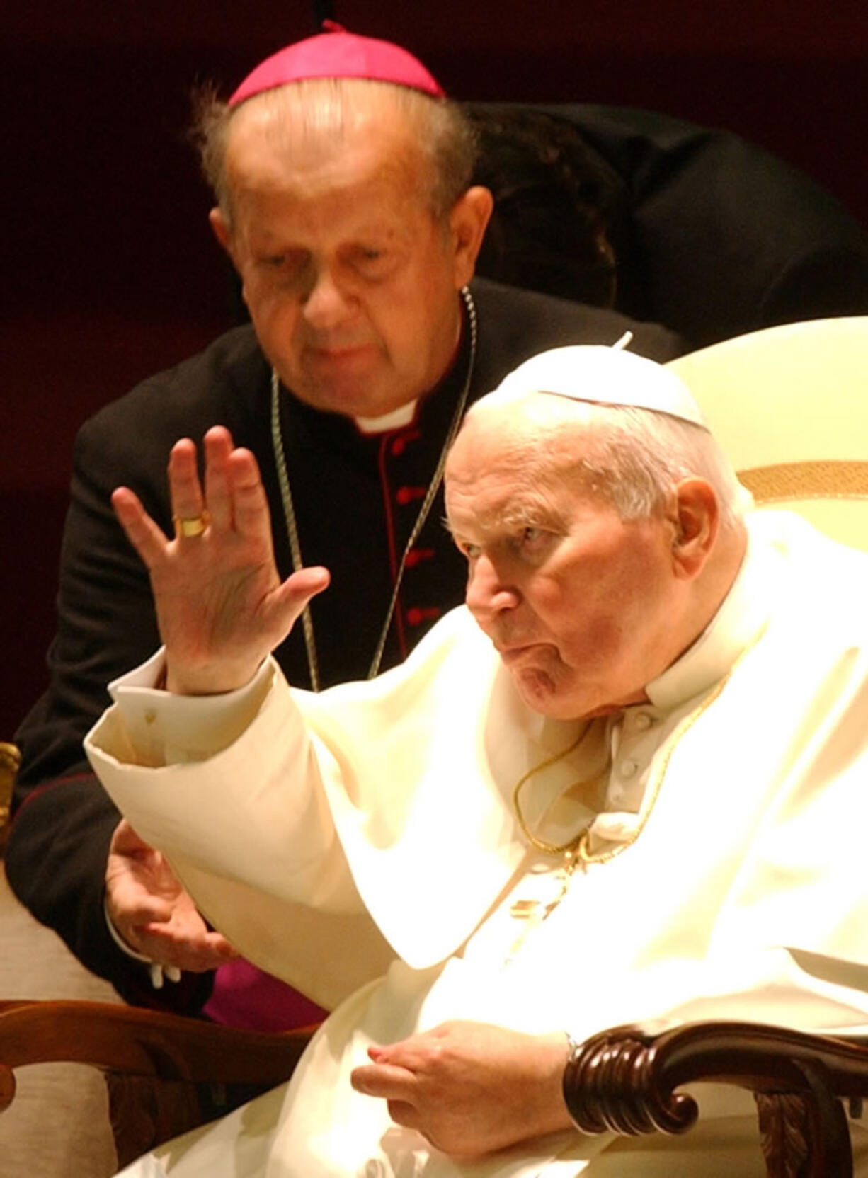 Archbishop Stanislaw Dziwisz assists a waving Pope John Paul II during a special audience Oct.