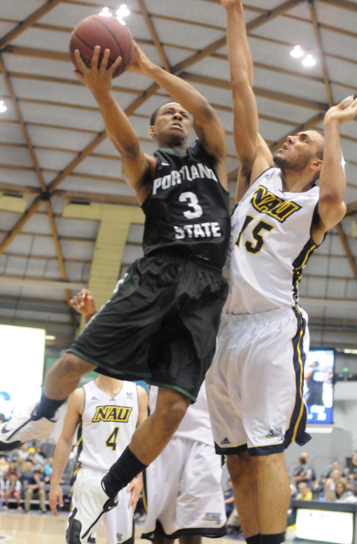 Portland State guard Andre Winston Jr. (3) tries for a shot against Northern Arizona defenders during Saturday's Big Sky Conference game at Flagstaff, Ariz.